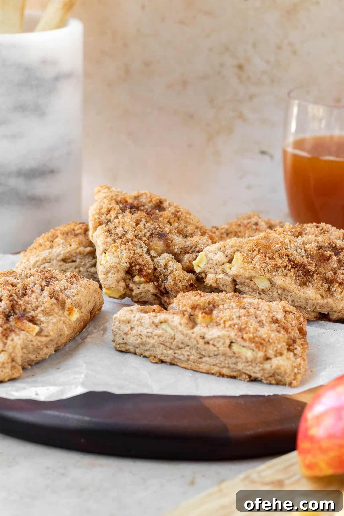 Apple Cinnamon Scones with Crunchy Cinnamon Streusel Topping 7 apple cinnamon scones on a wooden cutting board with a glass of apple cider in the background