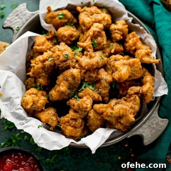Crispy Chicken Lollipops Recipe: Finger-Licking Party Snack 10 chicken pakoras in a bowl next to a green napkin