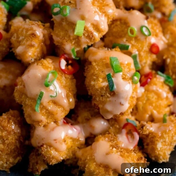 Crispy Chicken Lollipops Recipe: Finger-Licking Party Snack 14 Close up of Crispy Cauliflower with bang bang sauce topped with chillies and spring onions