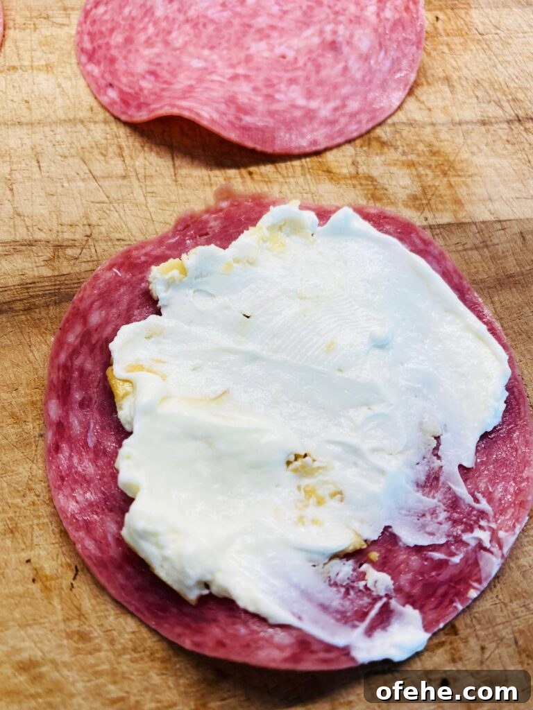 Smoked Salami and Roasted Pepper Pinwheels 5 spreading cream cheese on salami