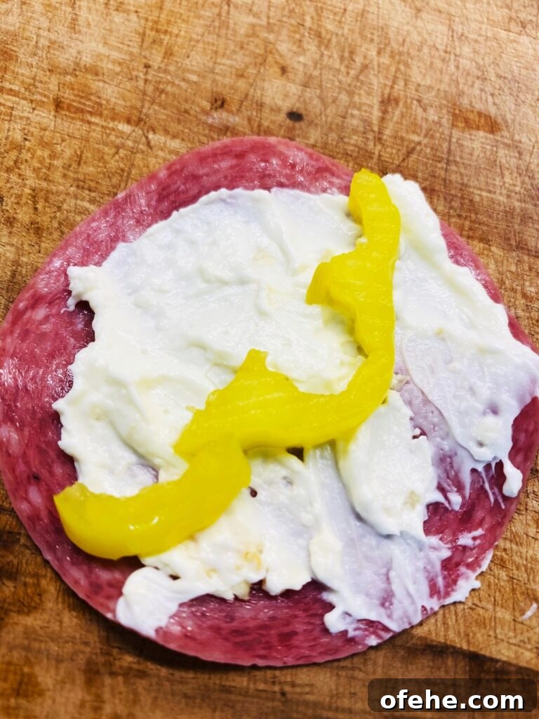 Smoked Salami and Roasted Pepper Pinwheels 6 adding babana pepper ring that was cut in half