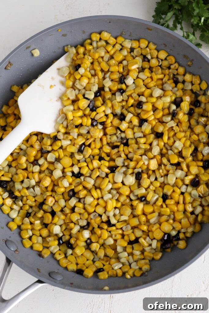 Vegan Elote-Style Corn Salad Recipe for Summer BBQs 4 frozen corn heated in pan with spatula