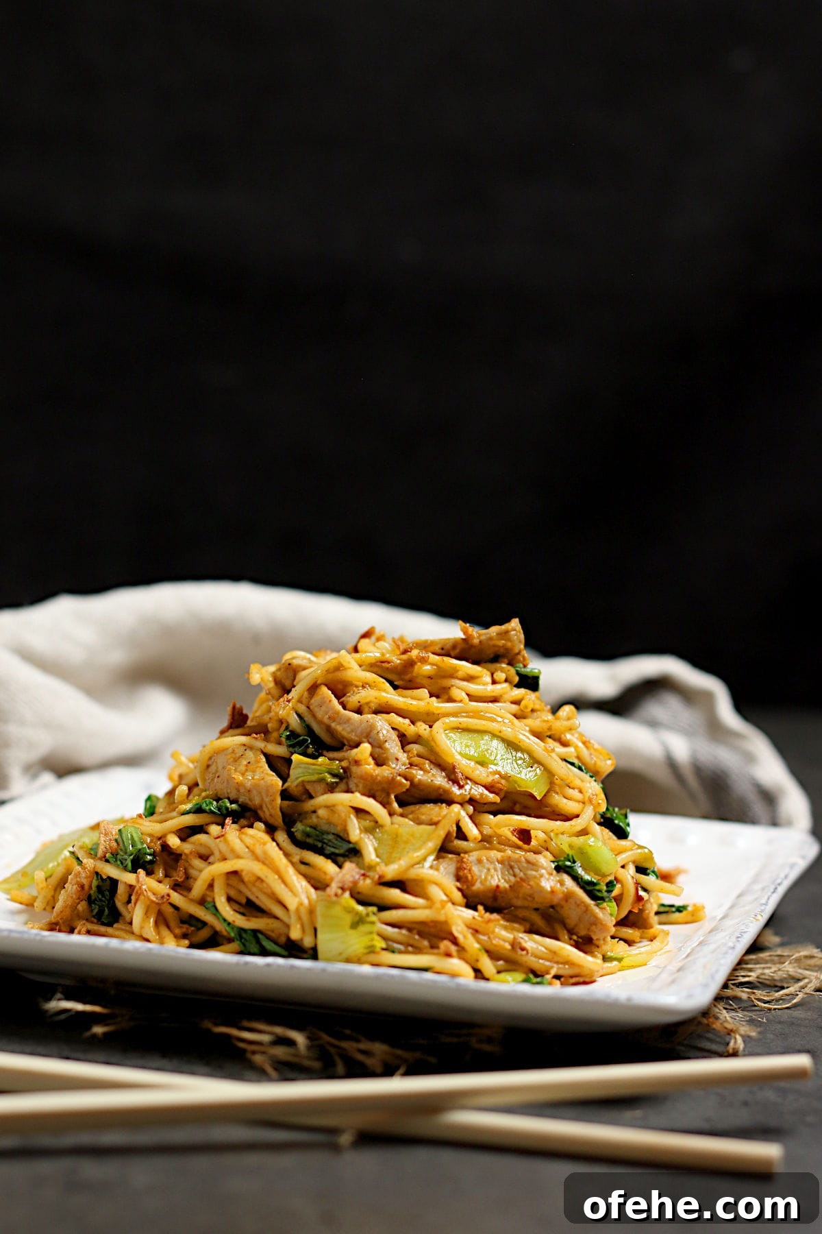 Sichuan-Style Spicy Pork Noodles with Bok Choy 2 Spicy Noodles with Pork and Bok Choy on a square, white plate.