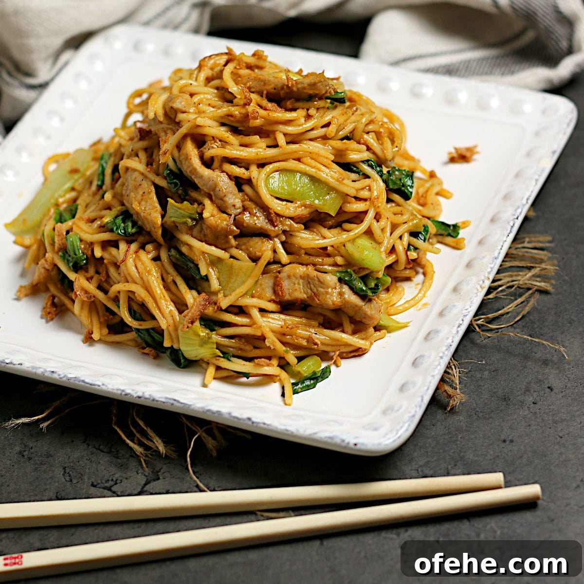 Sichuan-Style Spicy Pork Noodles with Bok Choy 6 Spicy Noodles with Pork and Bok Choy on a square, white plate.