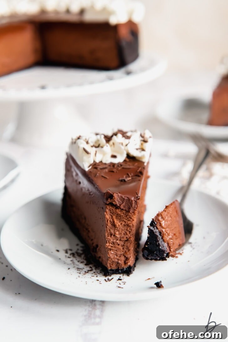 slice of chocolate cheesecake on a plate with fork holding a bite