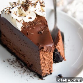 slice of chocolate cheesecake on a plate with fork holding a bite