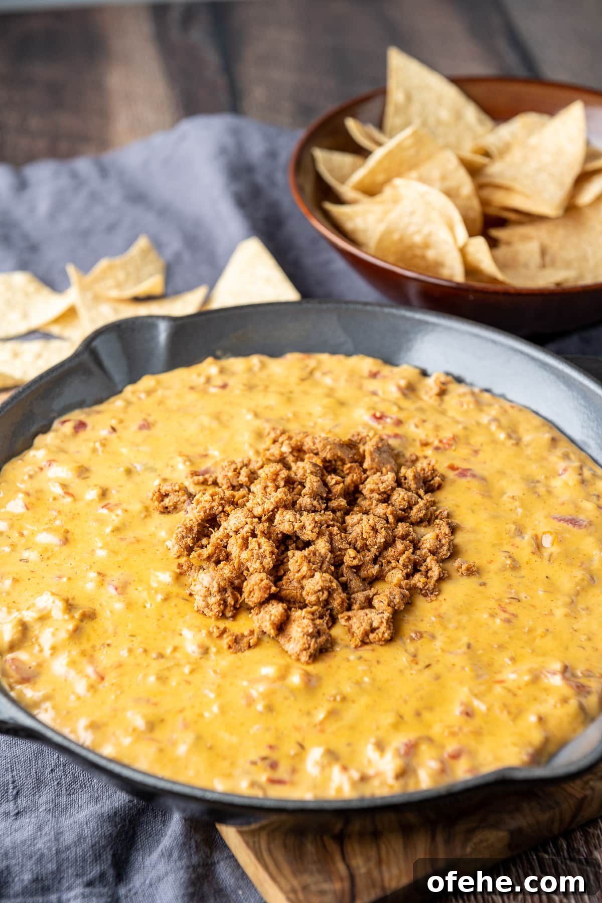Creamy Chorizo Dip Recipe for Game Day or Parties 2 A meat dip in a pan with chips in the back