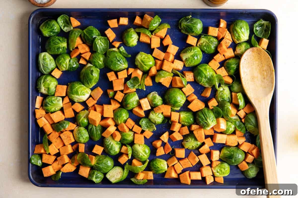 Autumn Harvest Chicken Bowls Recipe with Roasted Veggies 8 Sweet potato and Brussels sprouts on a baking sheet.