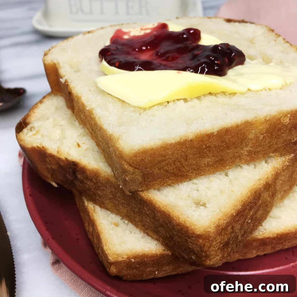 Authentic French Brioche Recipe for Soft, Buttery Loaves 2 Three slices of French brioche loaf with butter and jam on the red plate: Close up