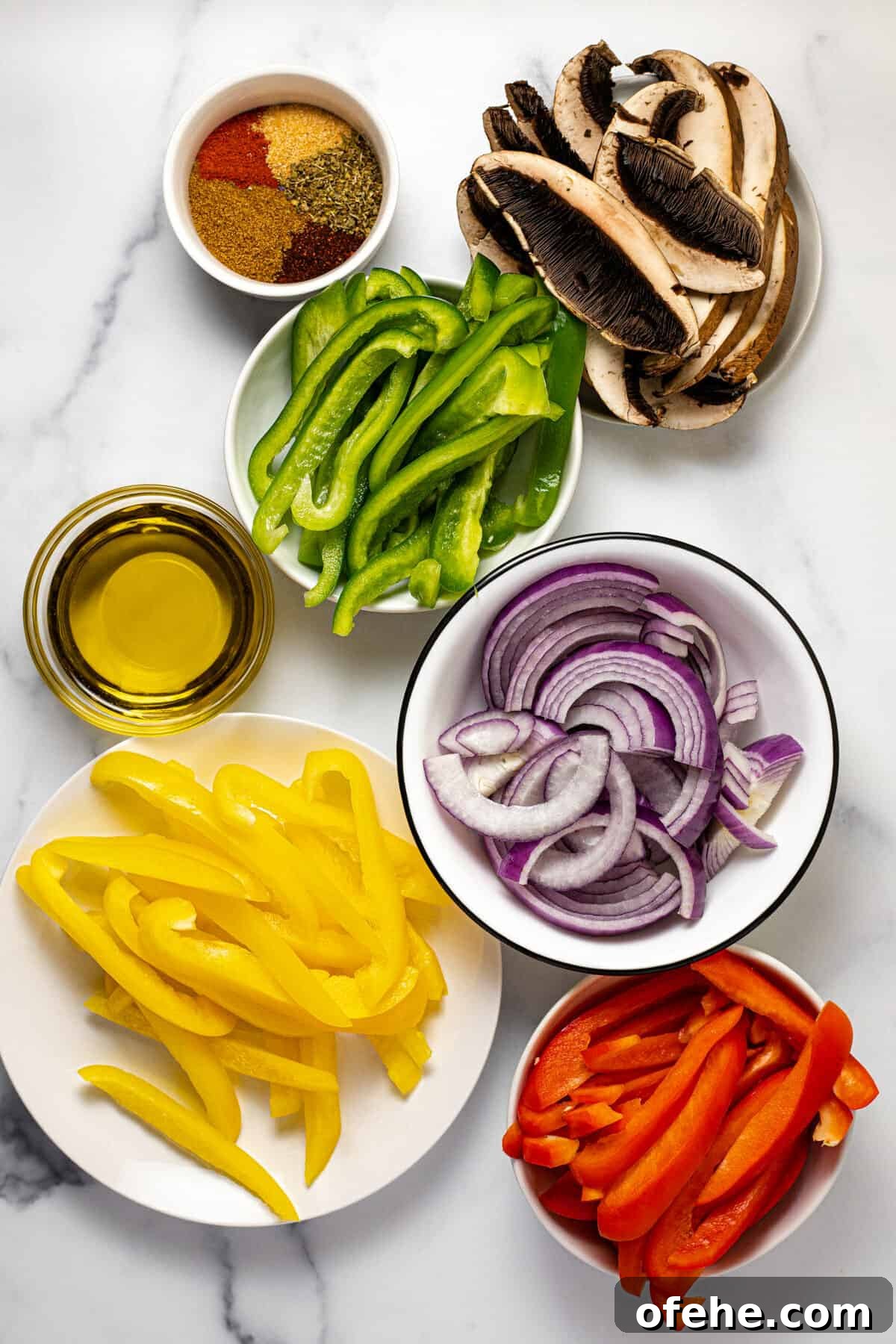 Oven-Baked Fajita Vegetables with Bell Peppers and Onions 3 White marble countertop with bowls of ingredients to make fajita veggies