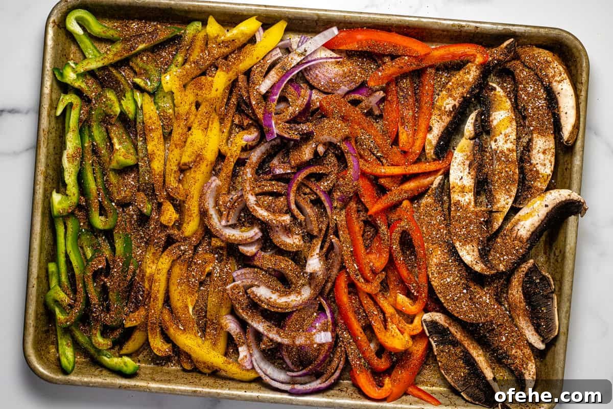 Oven-Baked Fajita Vegetables with Bell Peppers and Onions 5 Baking sheet filled with seasoned fajita veggies