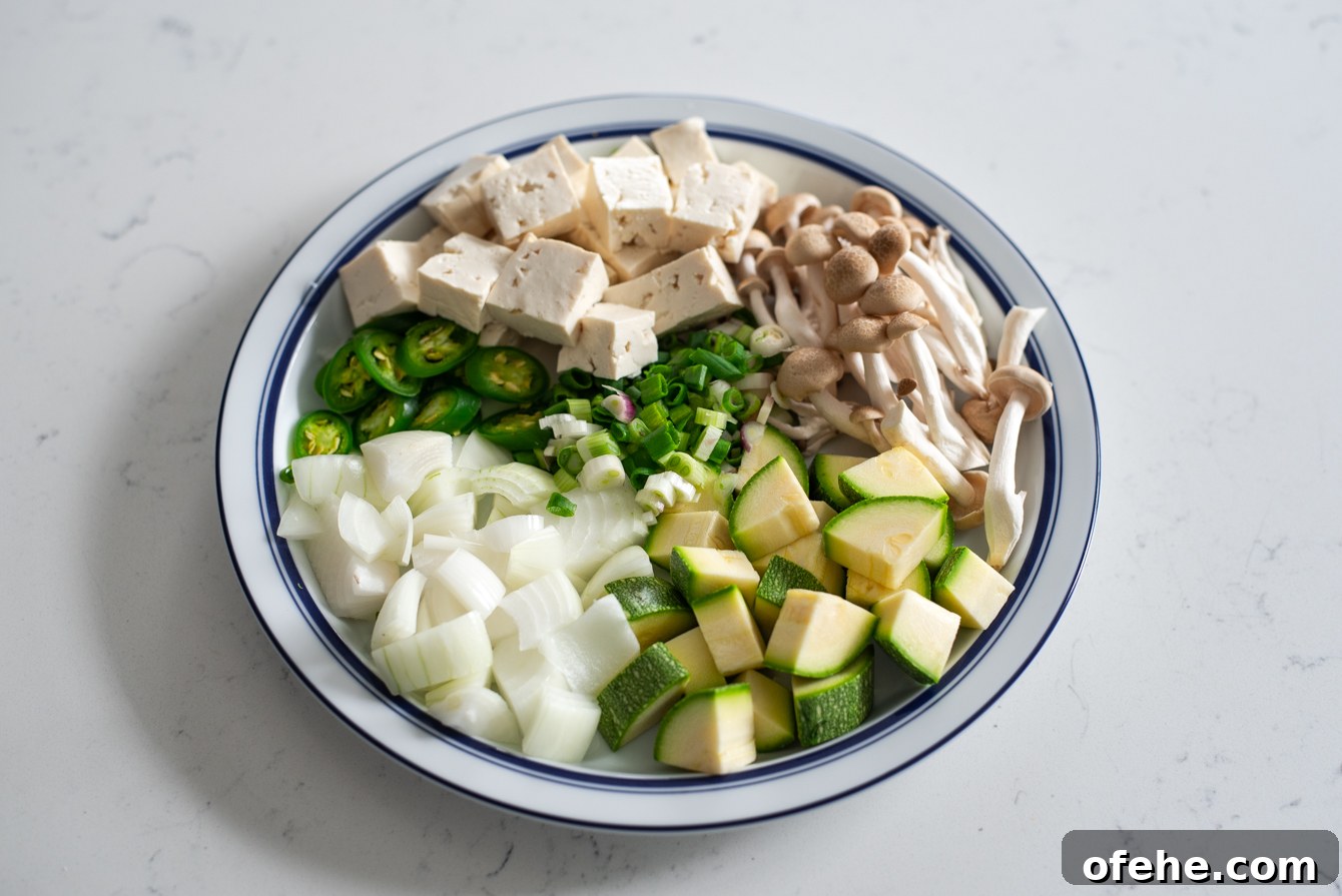 Authentic Doenjang Jjigae Recipe: Classic Korean Soybean Paste Stew 6 Fresh vegetables, mushrooms, and tofu prepared for doenjang jjigae