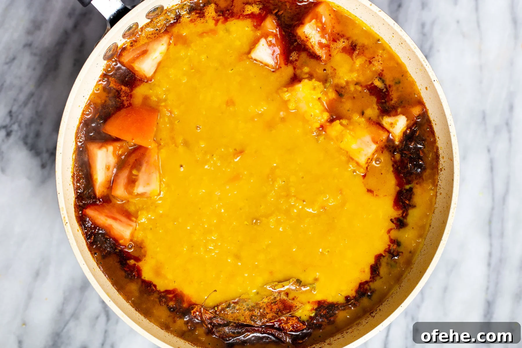 daal being added to a pan with indian tempering 