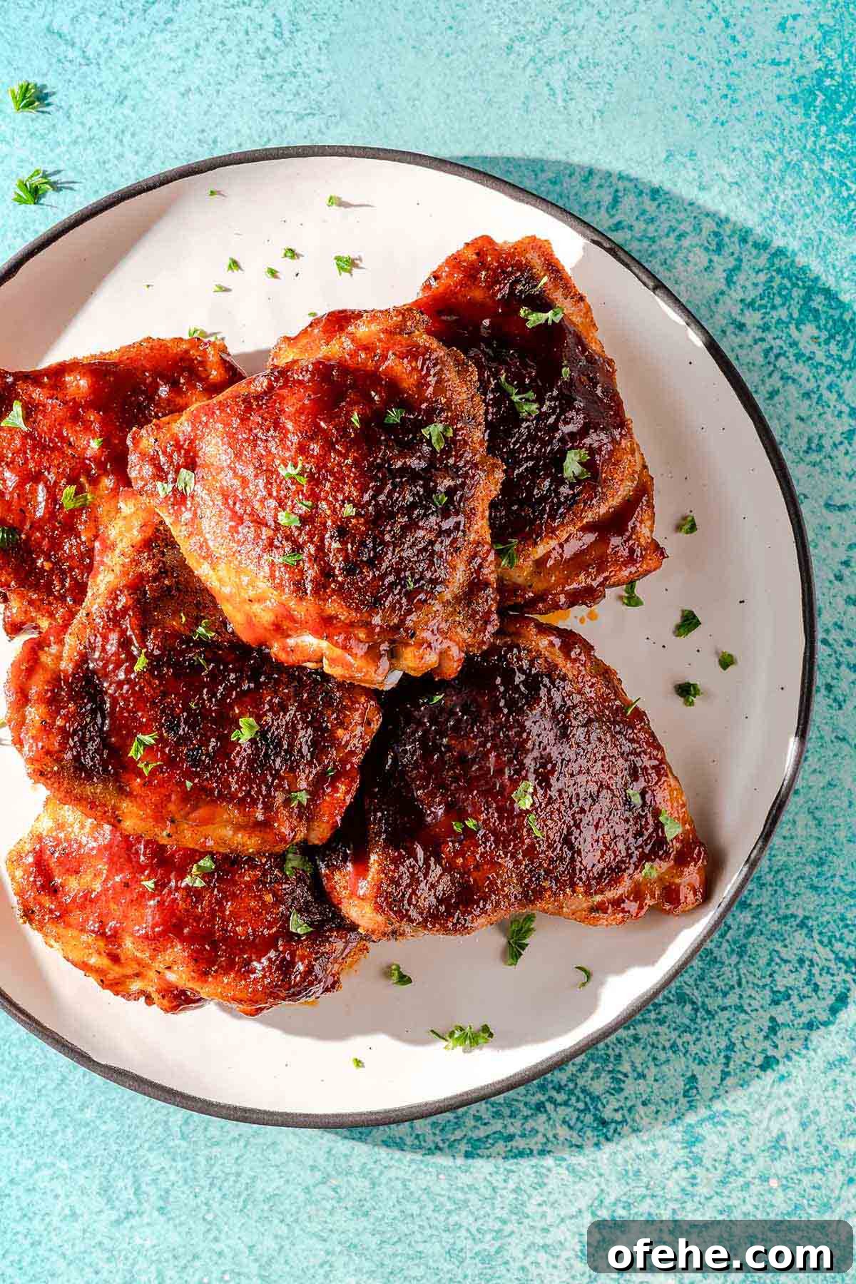 Juicy Baked BBQ Chicken Thighs with Crispy Skin 14 baked bbq chicken thighs on white plate
