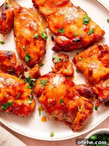 bbq chicken thighs on plate with parsley on the side.