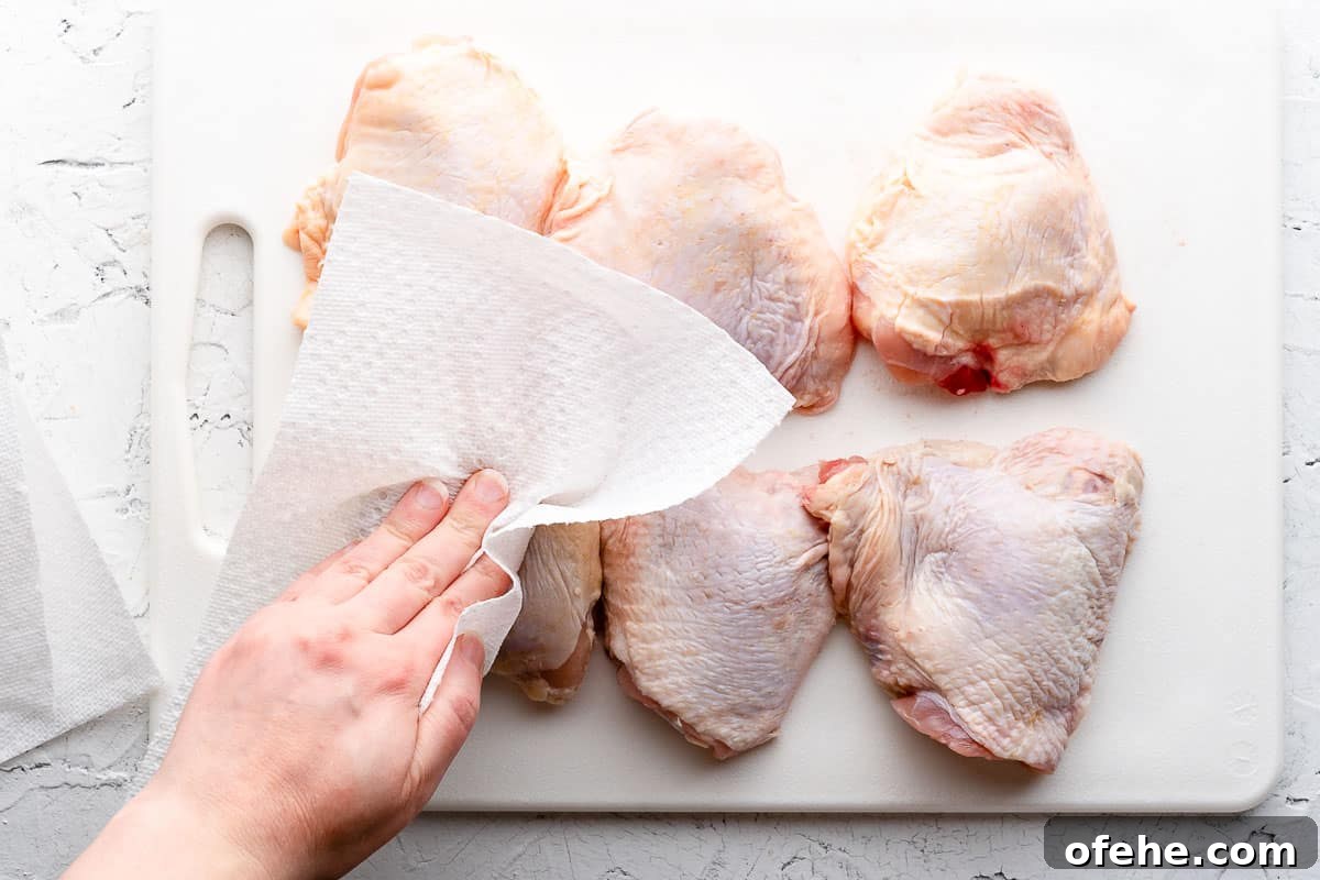 Juicy Baked BBQ Chicken Thighs with Crispy Skin 5 paper towel patting skin of chicken thighs dry