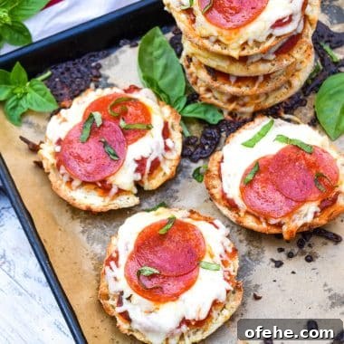 Mini English Muffin Pizzas: Quick Homemade Lunch or Snack 7 english muffin pizzas on a parchment paper lined baking sheet