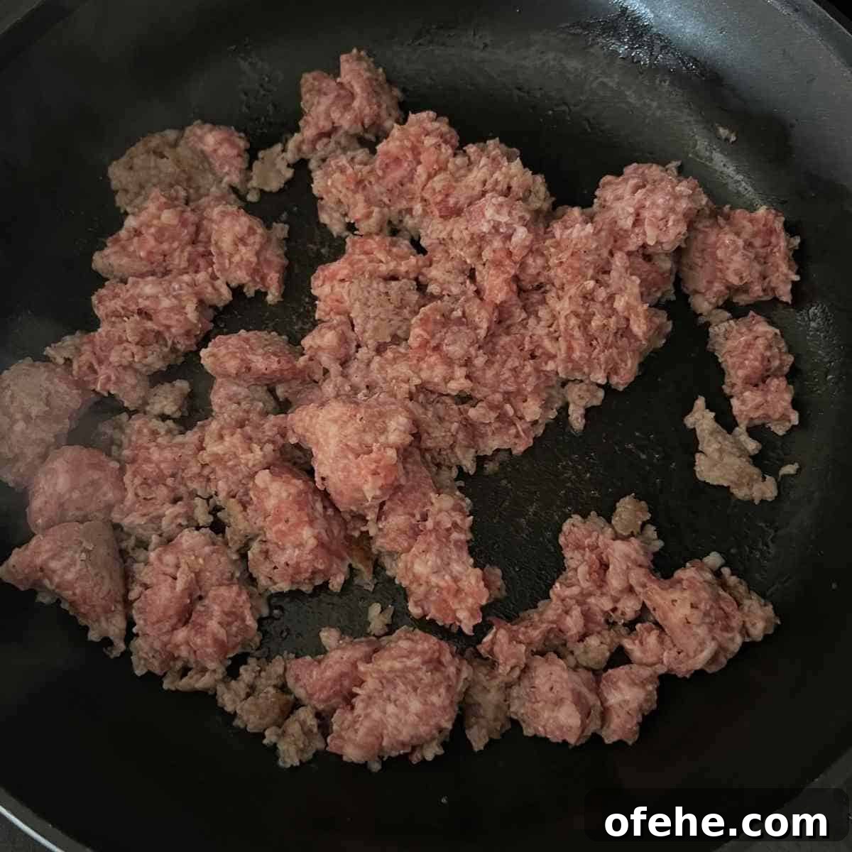 Carnivore Egg Bites Recipe with Bacon and Cheese 3 Pork sausage cooking in a skillet.
