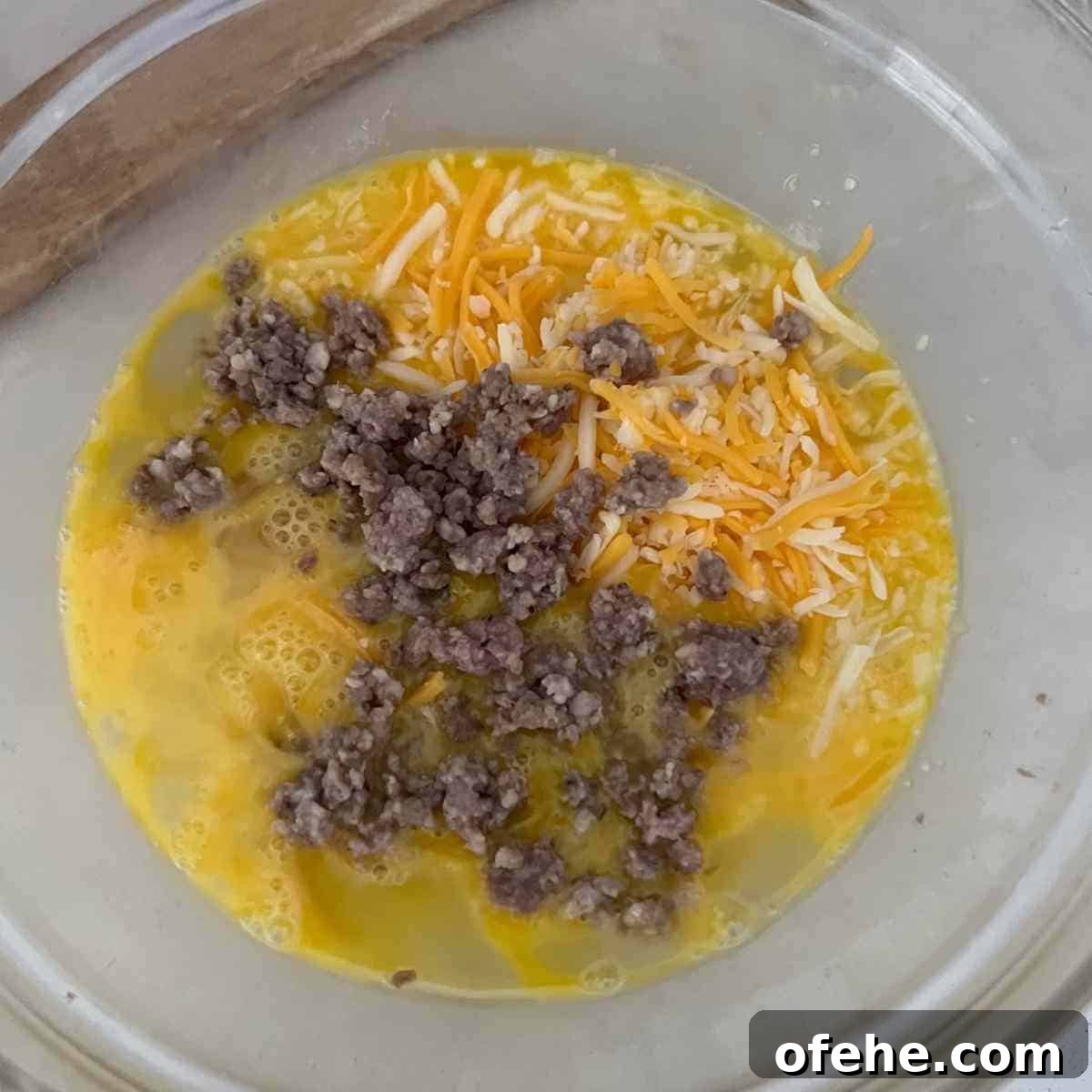 Carnivore Egg Bites Recipe with Bacon and Cheese 4 Egg mixture mixed together in a bowl.
