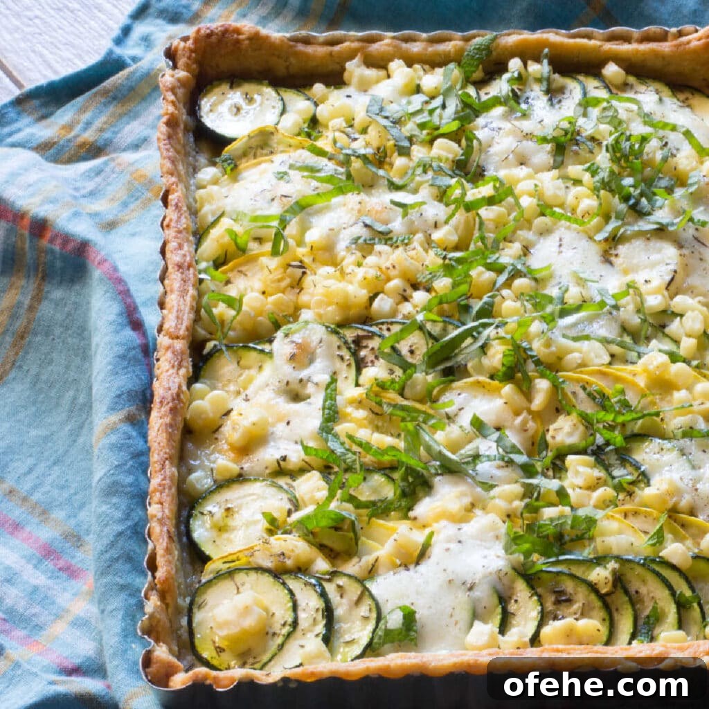 Tart filled with zucchini, summer squash, corn and cheese.
