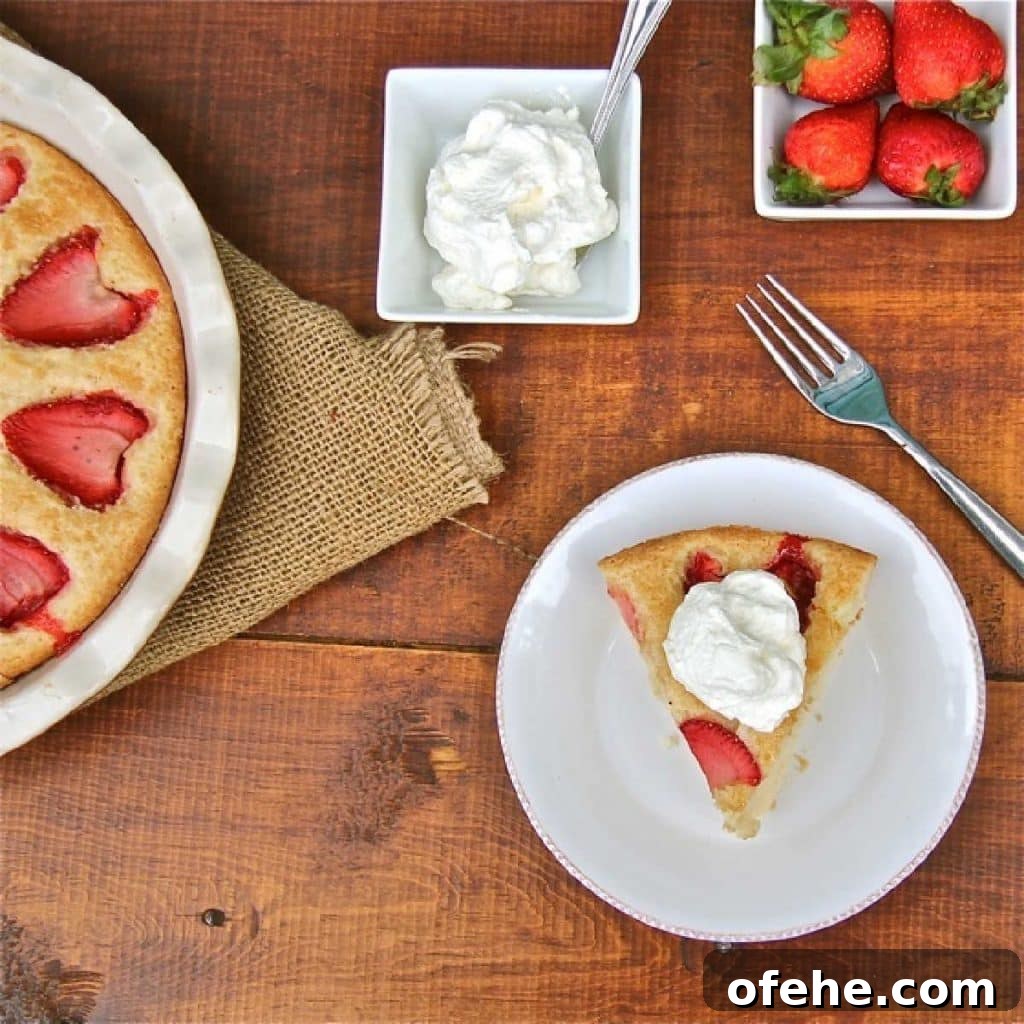 A piece of strawberry cake topped with whipped cream.
