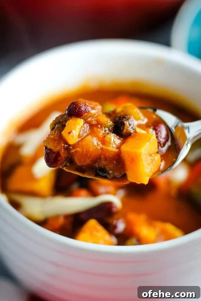 A spoonful of vegetarian sweet potato chili over a bowlful.