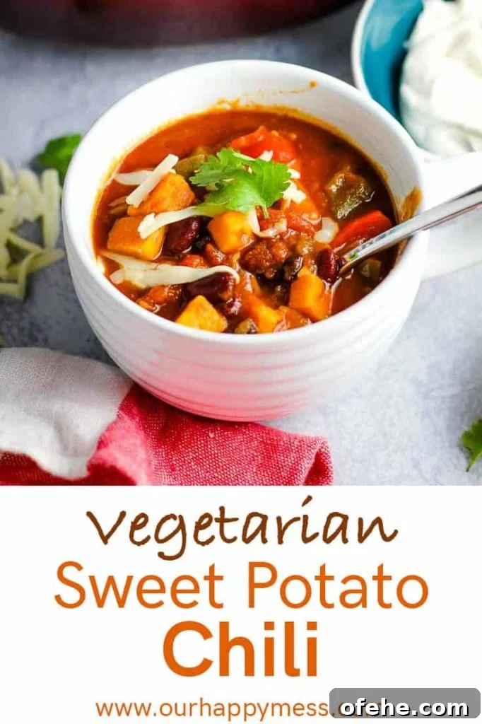 A bowl of vegetarian sweet potato chili topped with cheddar and cilantro