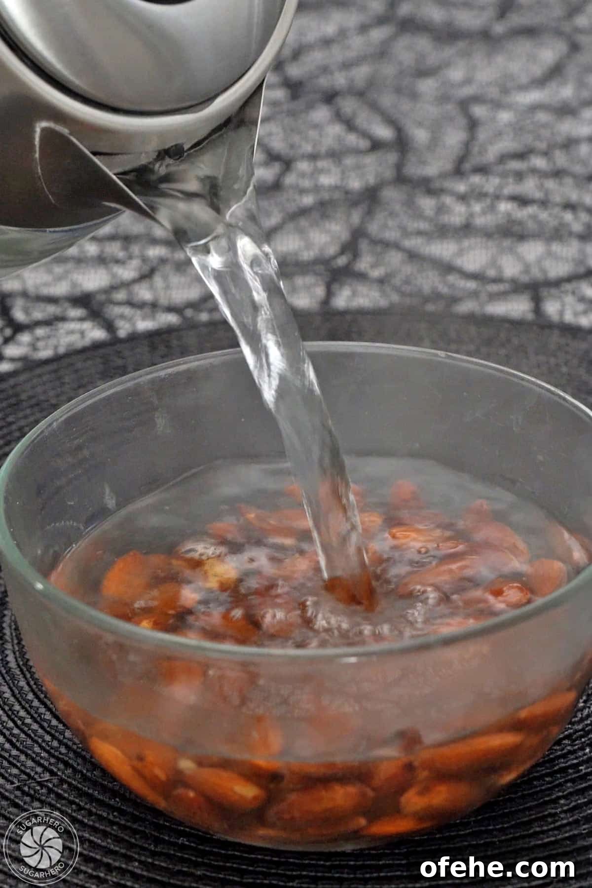 Spooky Witch Finger Cookie Recipe for Halloween Treats 12 Pouring boiling water over almonds in a bowl.