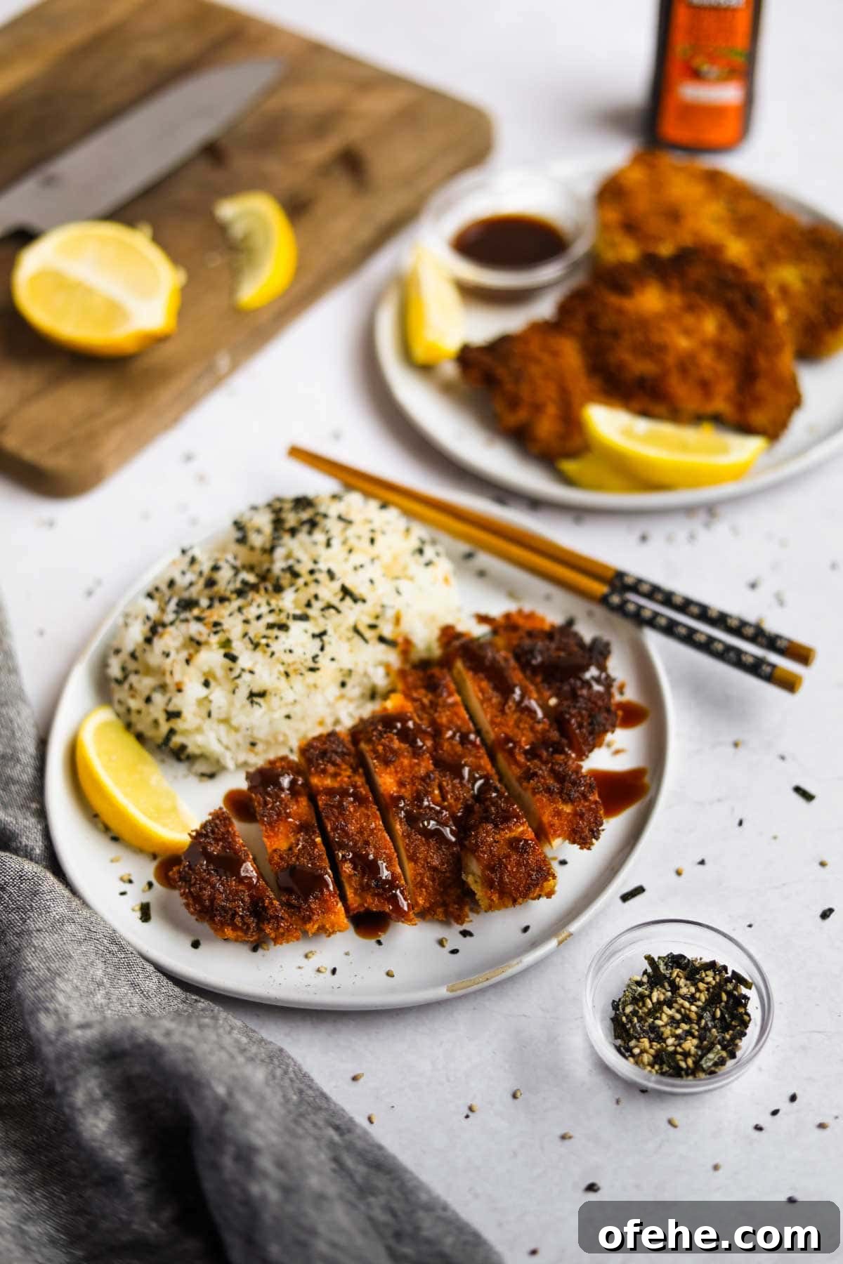 20 Delicious Dishes to Pair with Asparagus 13 Chicken Katsu (Japanese Chicken Cutlet) on a plate with rice with lemon slices and and furikake.