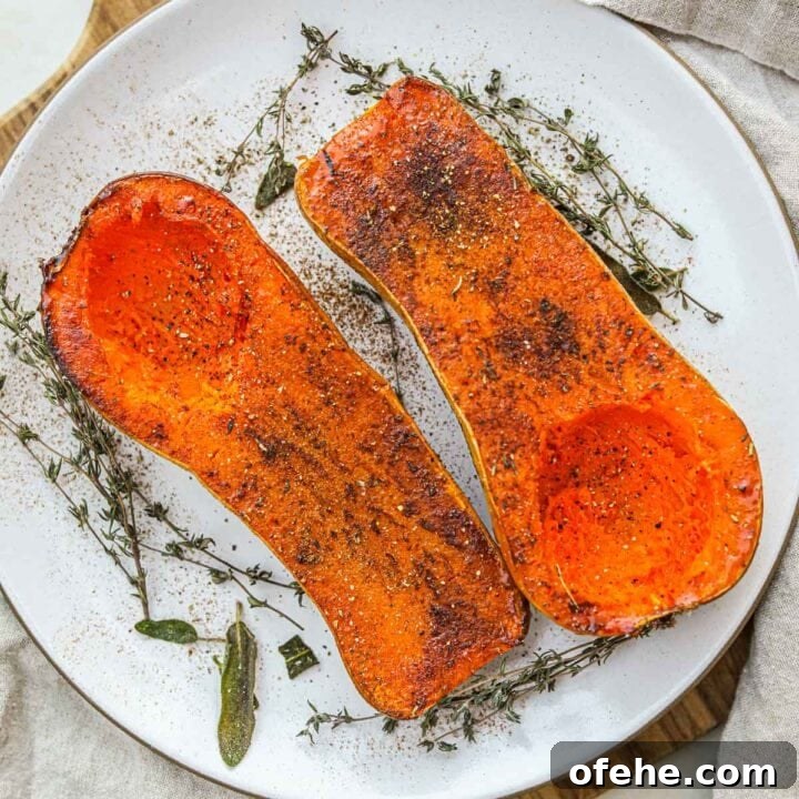 Oven roasted butternut squash on a serving platter with herbs.