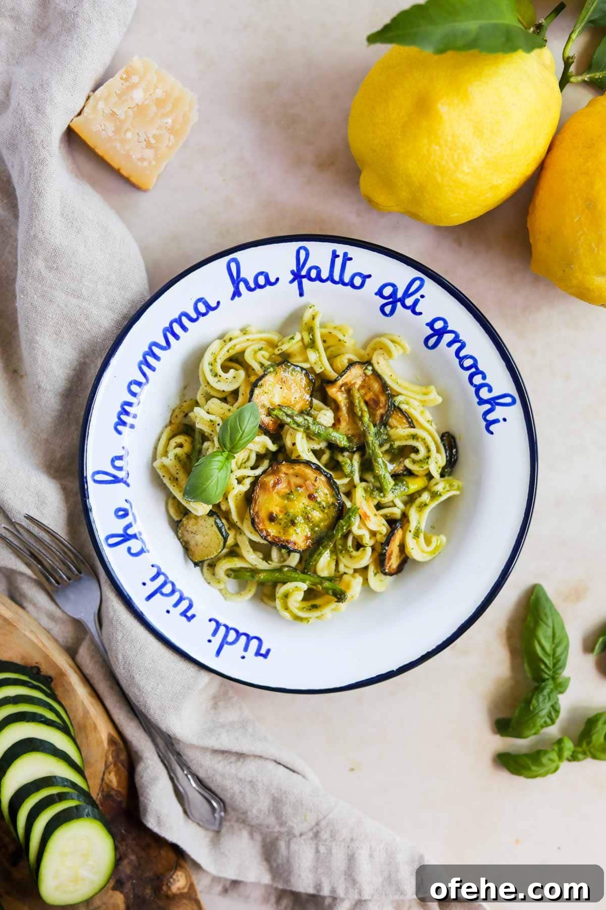 20 Delicious Dishes to Pair with Asparagus 6 Veggie pesto pasta in a bowl topped with zucchini and asparagus with sliced zucchini, basil, parmigiano-reggiano, and lemons.