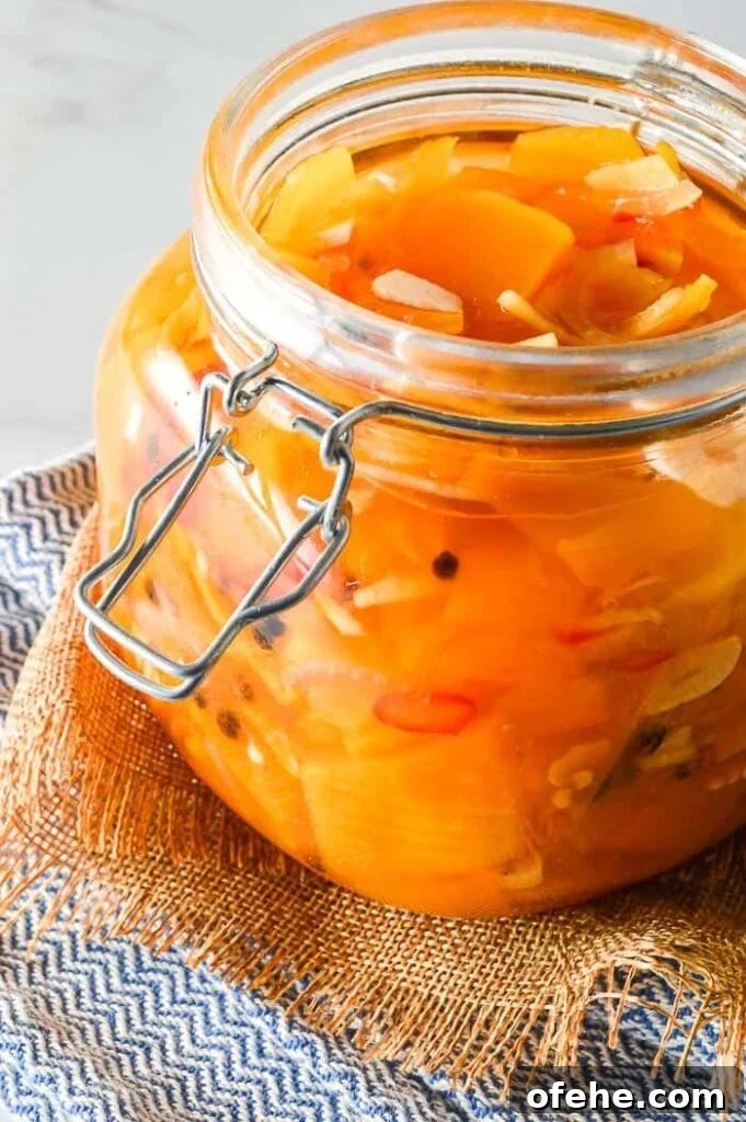 Front view of sliced pumpkin and garlic and red chilis in a glass jar