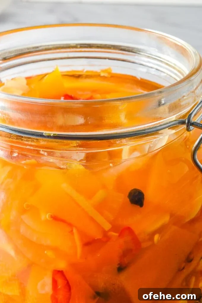 close up of jarred pumpkin pickles with pale grey background