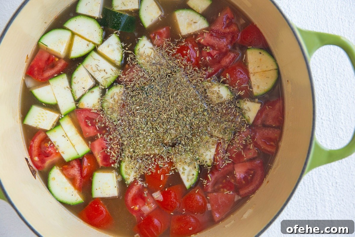 Soup pot with veggies and herbs.