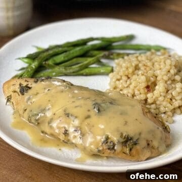 Crockpot Turkey Tenderloins in Honey Mustard Gravy 10 A cooked turkey tenderloin with Israeli couscous and green beans on a white plate.