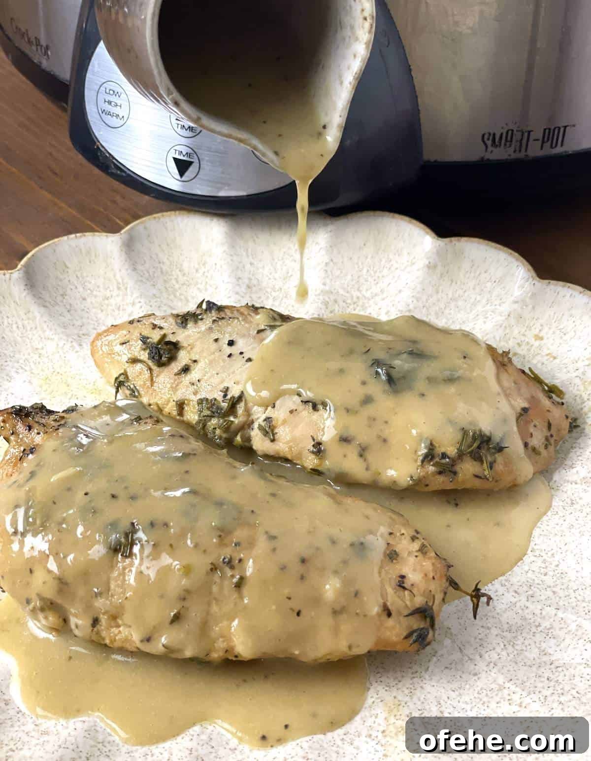 Crockpot Turkey Tenderloins in Honey Mustard Gravy 6 Two whole turkey tenderloins on a scalloped plate with gravy being poured over the top.