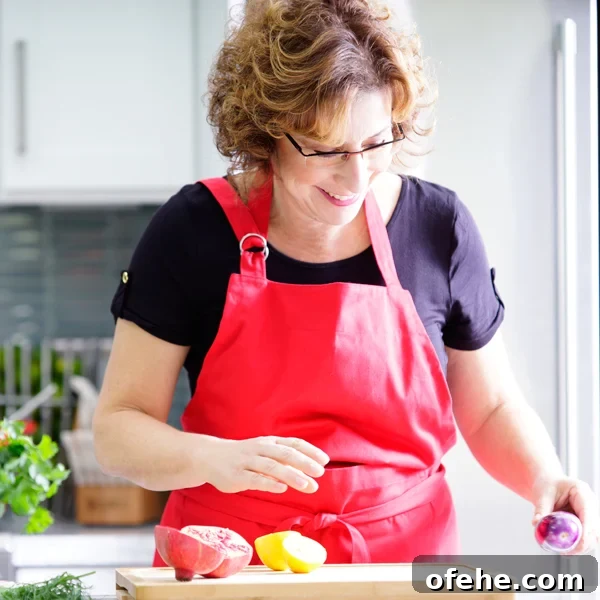 Fruit Compote Ideas: Delicious Pancake Toppers and More 10 Beth Lee in red apron looking at vegetables on cutting board