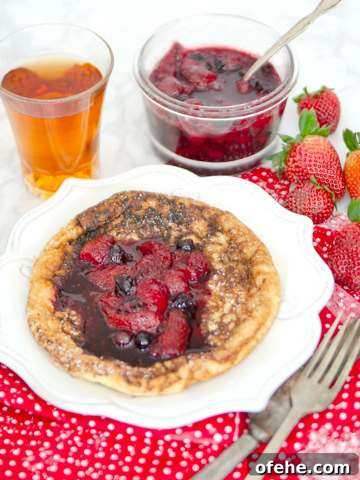Fruit Compote Ideas: Delicious Pancake Toppers and More 8 Berry fruit compote spooned on pancake with extra in a glass bowl in the background.