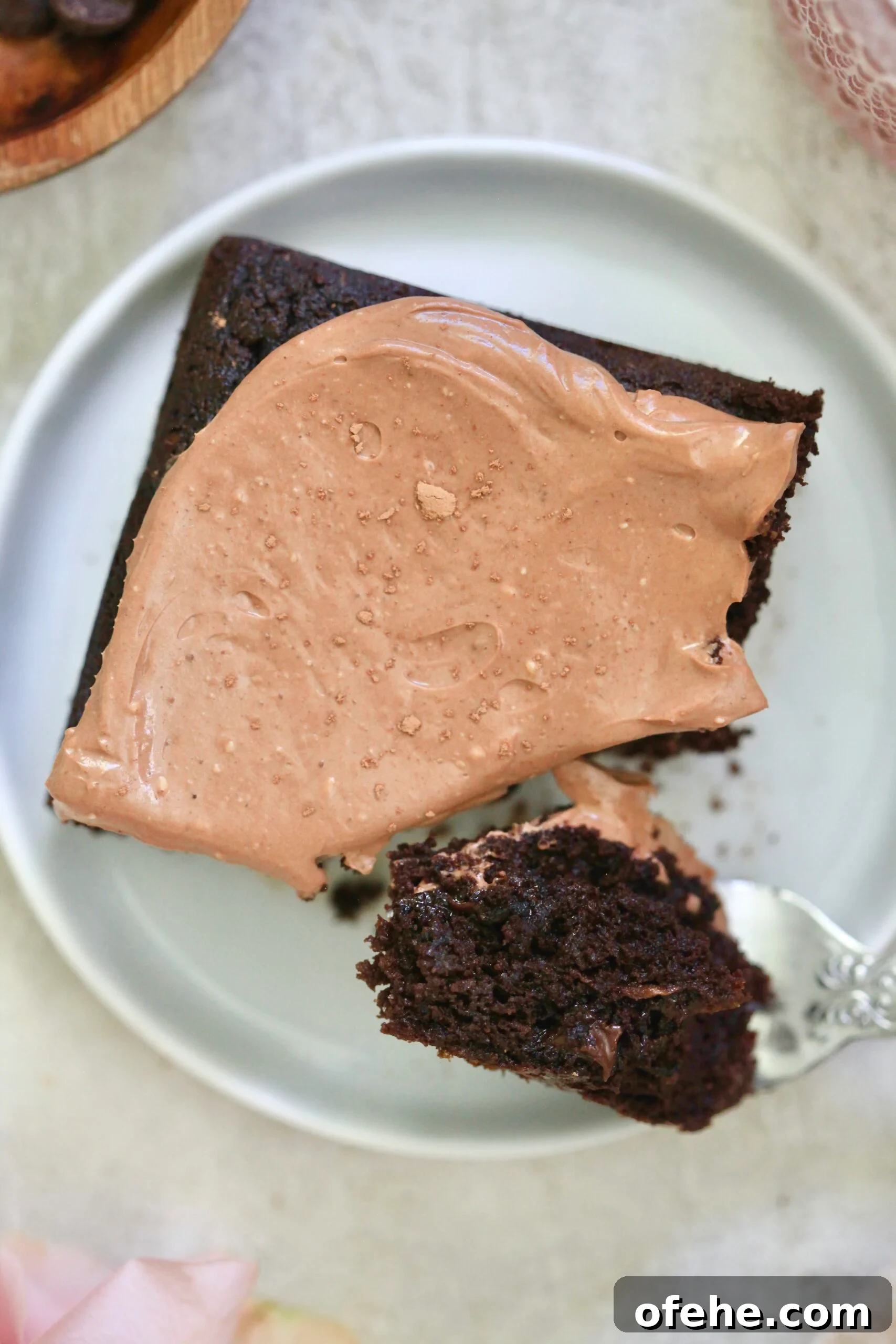 Decadent Chocolate Zucchini Cake That Actually Nourishes 2 frosted cake with fork taking bite out.