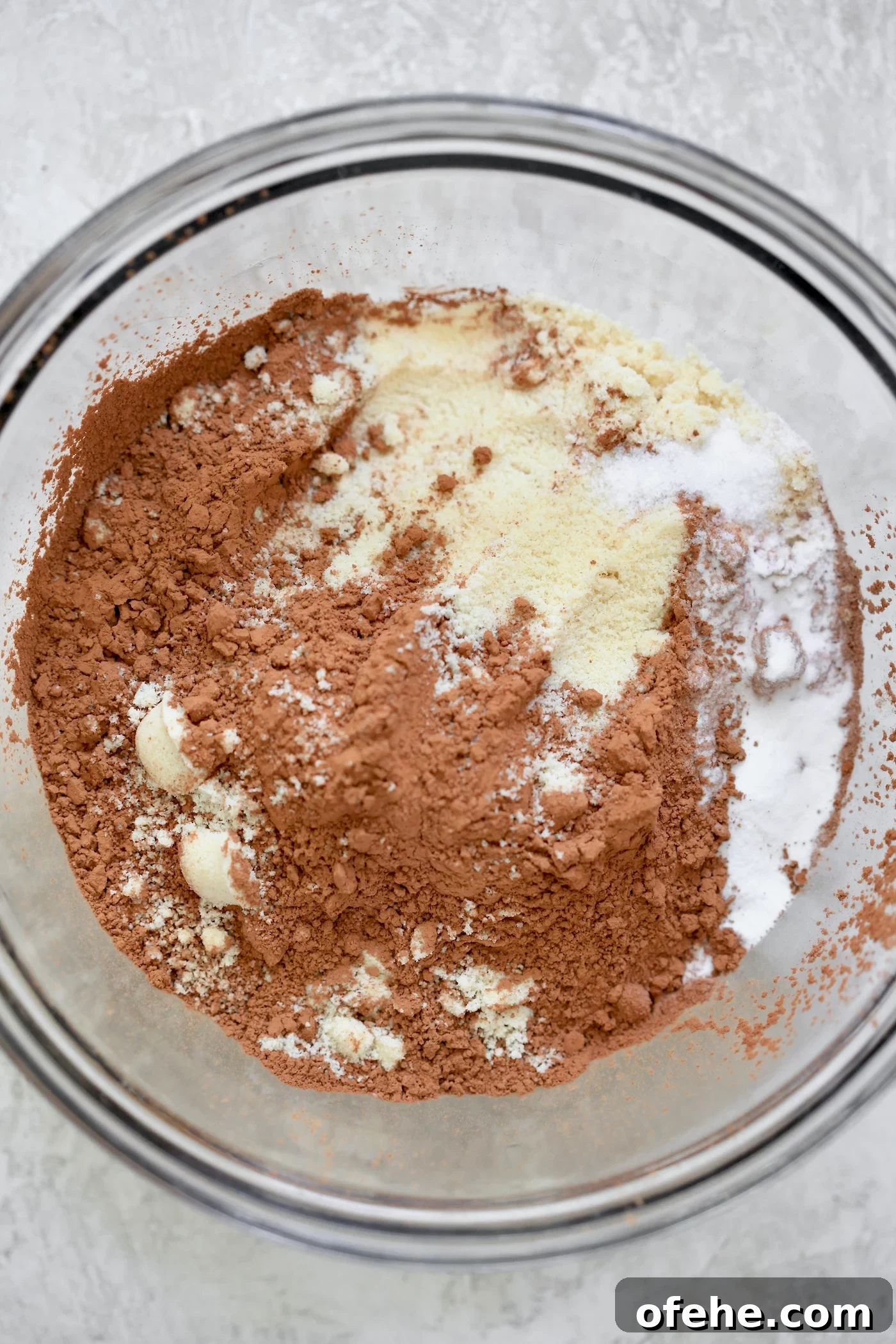 Decadent Chocolate Zucchini Cake That Actually Nourishes 3 Cocoa powder and flour in glass mixing bowl.