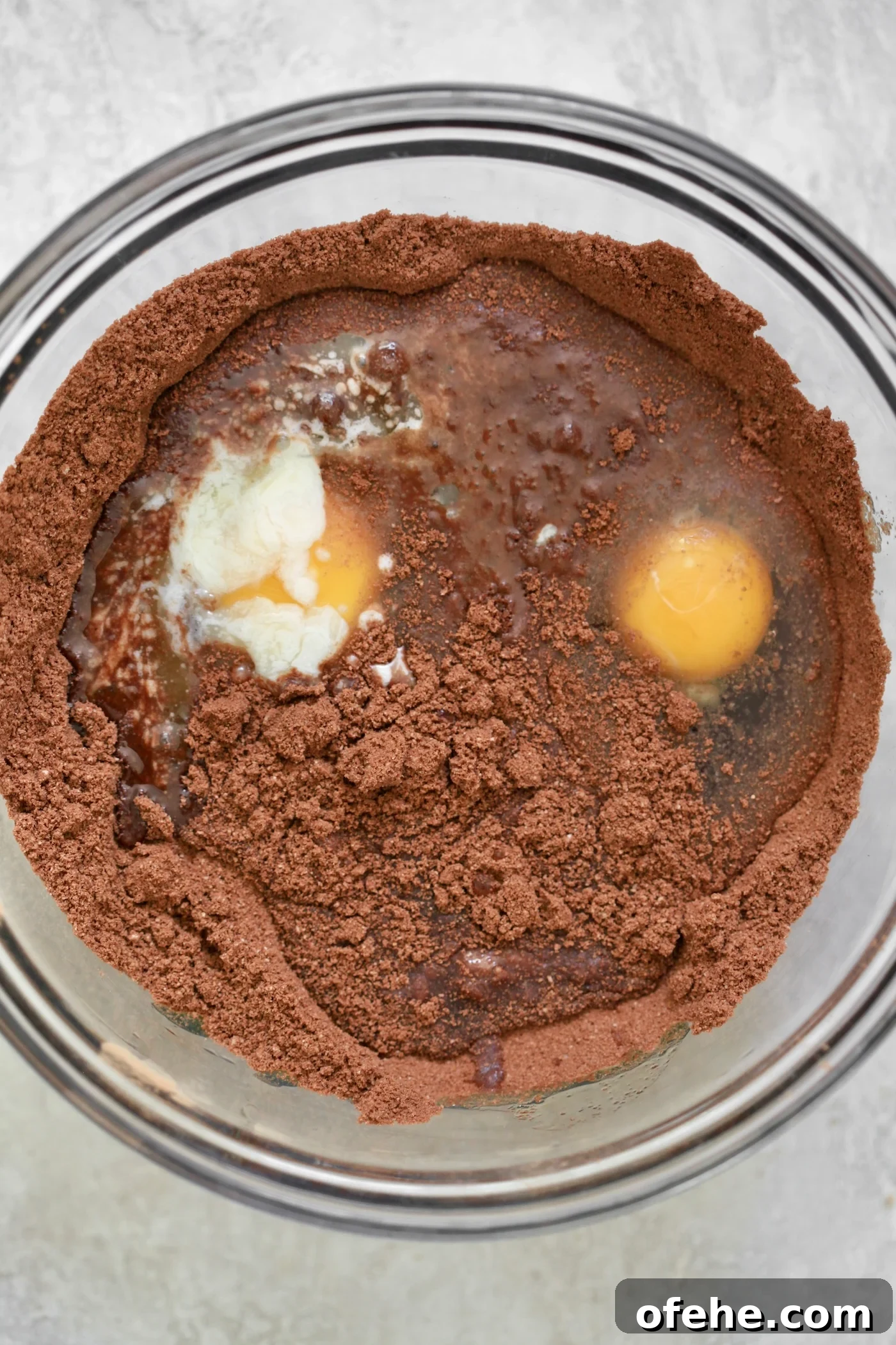 Decadent Chocolate Zucchini Cake That Actually Nourishes 4 mixing bowl with cocoa powder and eggs.