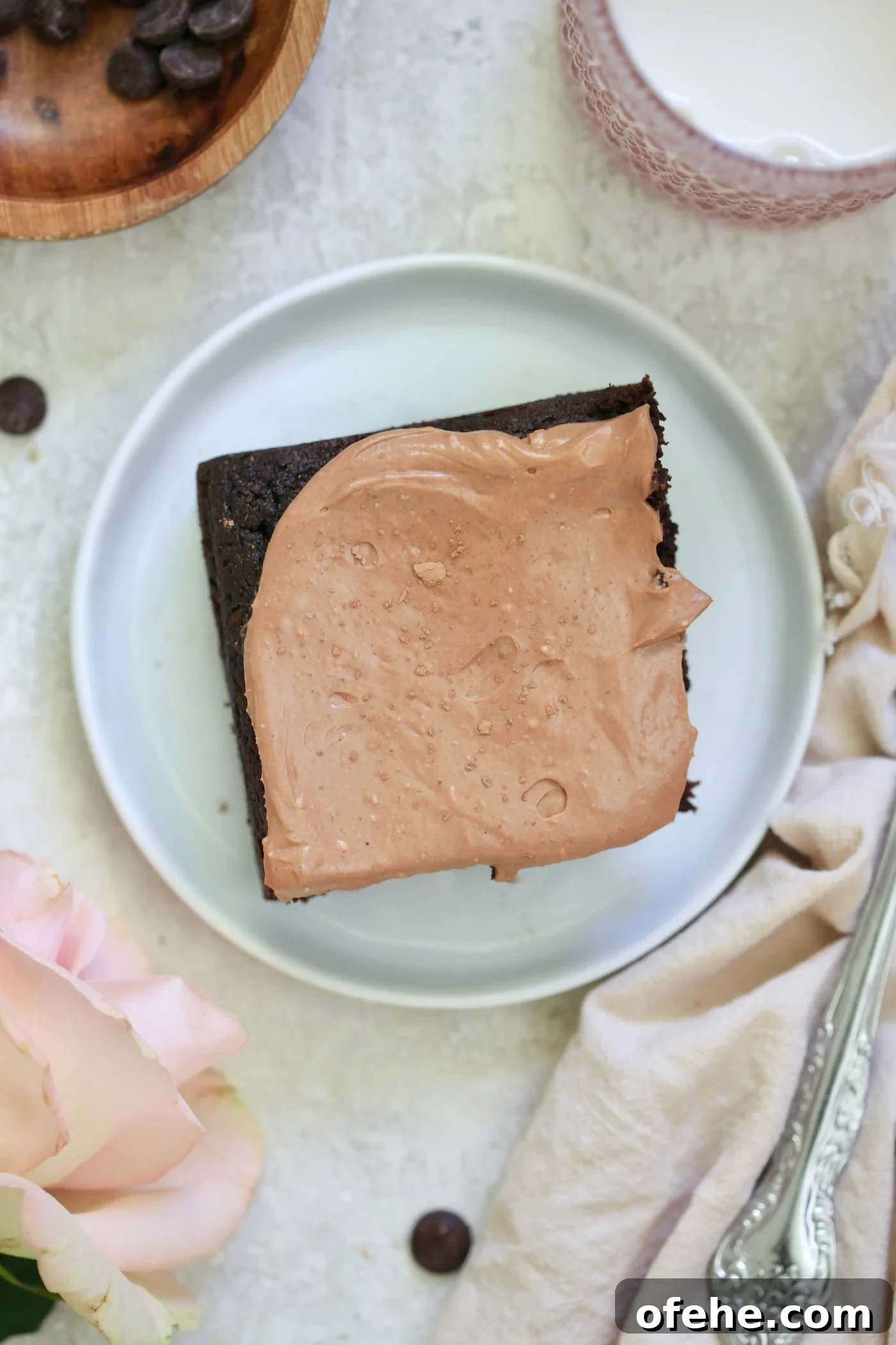 Decadent Chocolate Zucchini Cake That Actually Nourishes 10 piece of chocolate cake with frosting on white plate.