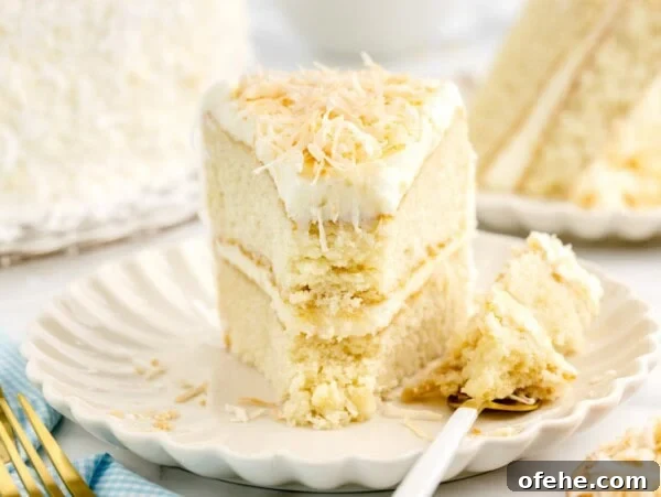 Homemade Pineapple Upside-Down Cake Recipe for Perfect Results 8 A slice of layered coconut cake on a white plate.