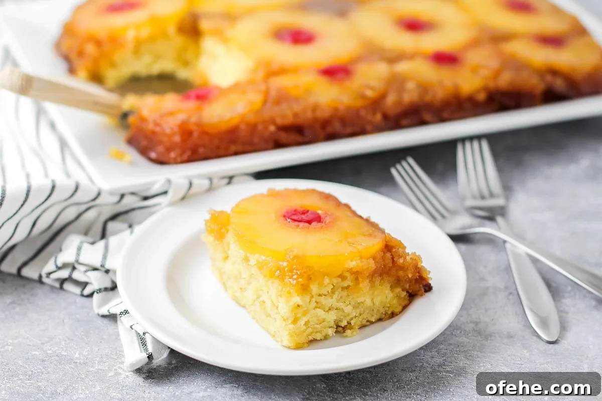 Our best pineapple upside down cake is a family favorite with a secret ingredient that takes this classic to a whole new level! A slice of pineapple upside down cake on a white plate.