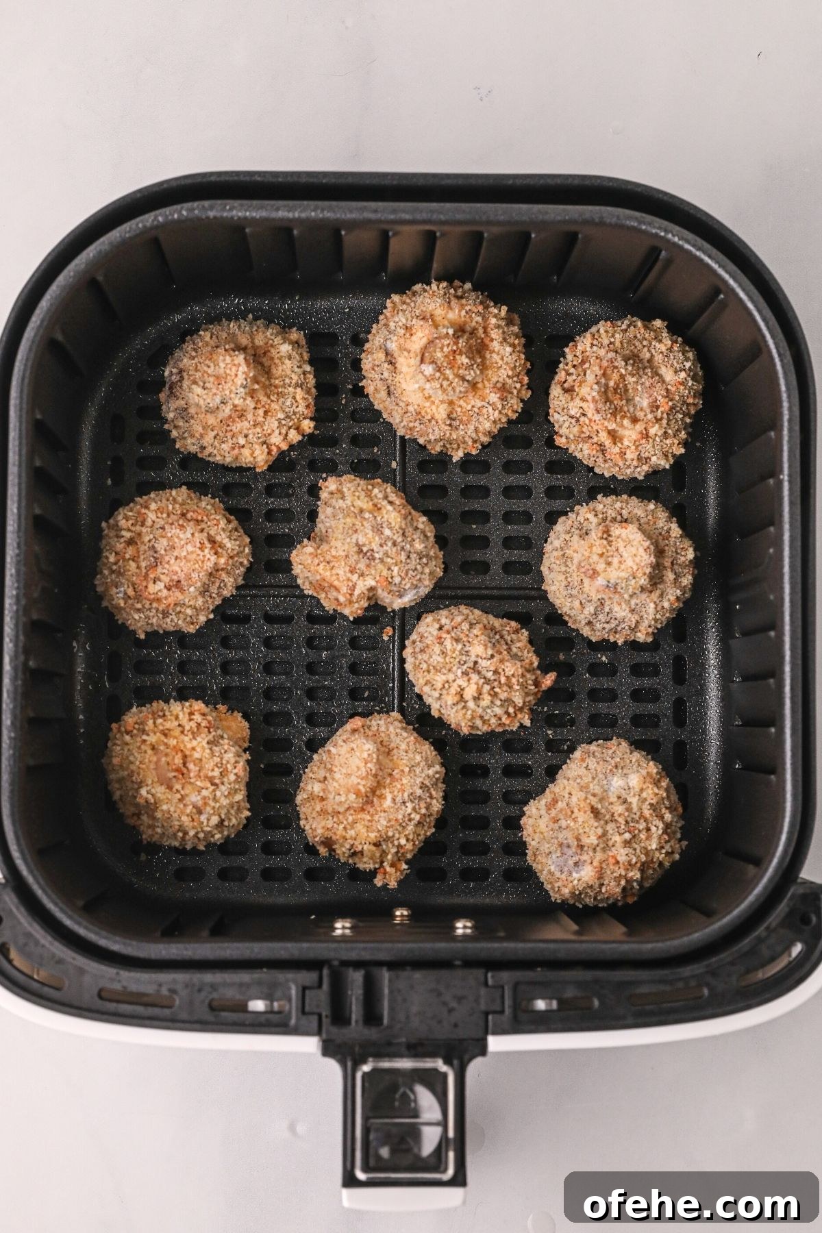 Crispy Air-Fried Mushrooms Recipe for Quick Snacks 6 Battered mushrooms in the air fryer basket before being cooked