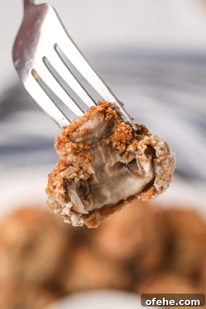 Crispy Air-Fried Mushrooms Recipe for Quick Snacks 8 Golden crispy bit of fried mushroom on a fork with a bit missing