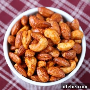 Maple Sriracha Roasted Nuts Recipe — Sweet-Spicy Snack Guide 6 maple sriracha roasted nuts in a white ramekin on a burgundy and white kitchen towel.