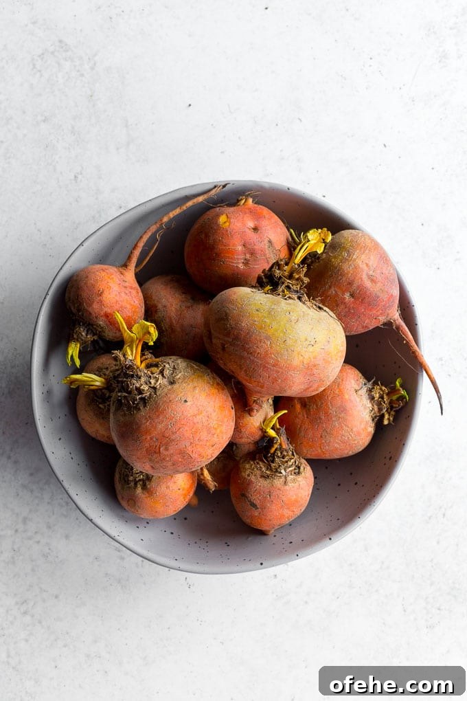 Golden Beet, Carrot & Ginger Soup — Vegan Recipe Guide 3 Large bowl of unpeeled golden beets on a light coloured surface.