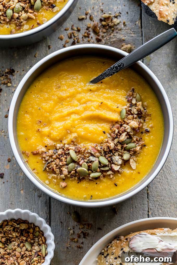 Golden Beet, Carrot & Ginger Soup — Vegan Recipe Guide 5 Up-close overhead view of golden beet soup in a grey bowl with granola sprinkled on top.