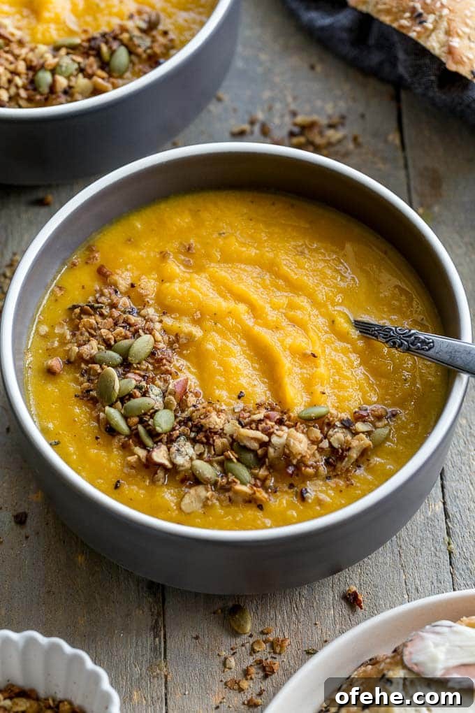 Golden Beet, Carrot & Ginger Soup — Vegan Recipe Guide 7 Up-close view of golden beet soup in a grey bowl.